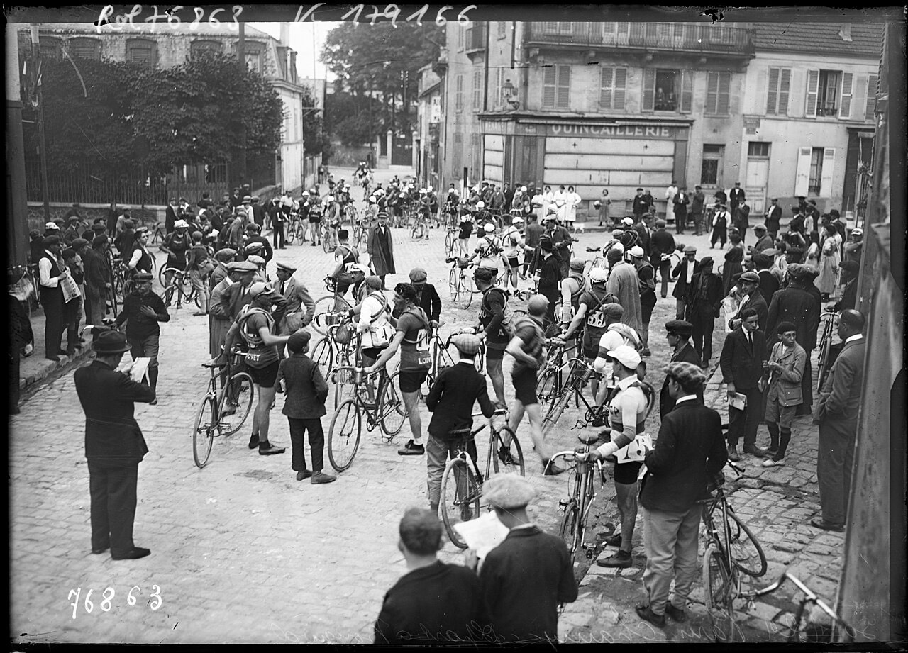 Coureurs et spectateurs rassemblés sur une place pavée de Bougival avant le départ, en 1922
