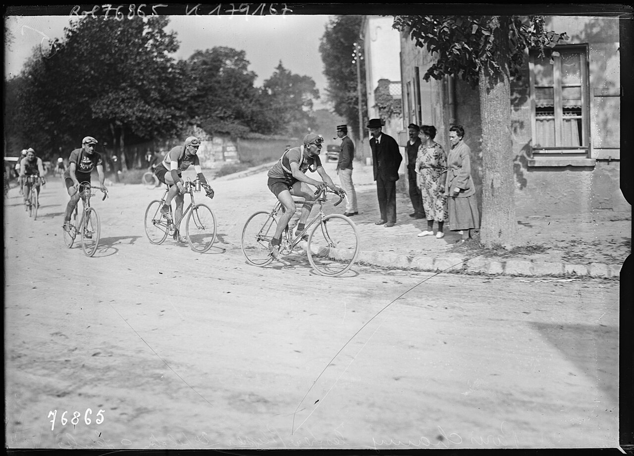 Trois coureurs de tête passent devant des spectateurs à Senlis, en 1922